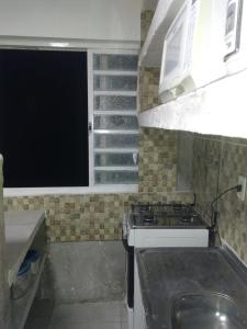 een kleine keuken met een fornuis en een raam bij cantinho bom in Ubatuba +9 foto's