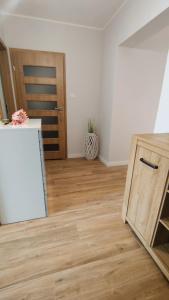 eine Küche mit Holzboden und einer Holztür in der Unterkunft Apartament 10 in Płock