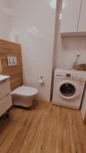 ein Badezimmer mit einer Waschmaschine und einem WC in der Unterkunft Apartament 10 in Płock