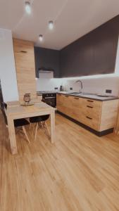 eine Küche mit einem Holztisch und Holzböden in der Unterkunft Apartament 10 in Płock