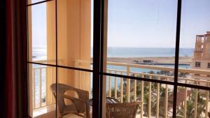 um quarto com uma varanda com vista para o oceano em أزهار الكرز "سويت ملكي مطل على البحر" em King Abdullah Economic City