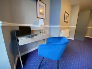 a blue chair in a room with a television at Queens Hotel in Newport