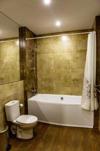 a bathroom with a toilet and a bath tub at Hotel Shengen "Шенген" in Kropyvnytskyi