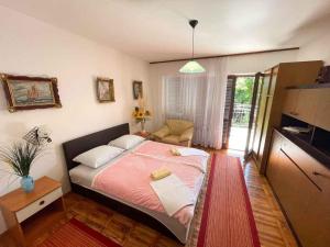een slaapkamer met een groot bed en een roze deken bij Apartment in Jadranovo 41878 in Jadranovo