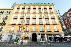 um grande edifício amarelo com um sinal nele em Sant'Angelo Suites em Nápoles