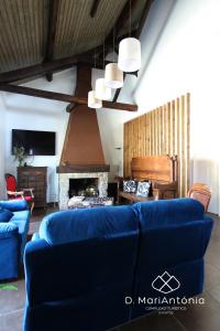 a living room with a blue couch and a fireplace at D. MariAntónia Complexo Turístico in Bragança