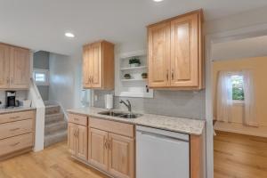 eine Küche mit Holzschränken und einem Waschbecken in der Unterkunft Amazing Lakefront Retreat On Long Lake! home in Portage