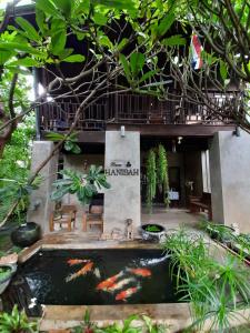 a koi pond in front of a house at Baan Hanibah in Chiang Mai