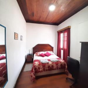 Un dormitorio con una cama y una ventana en Hostal Cotroneo, en Viña del Mar