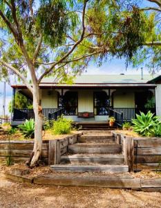 ein Haus mit einer Treppe vor einem Baum in der Unterkunft Rustic on 13th in Gawler