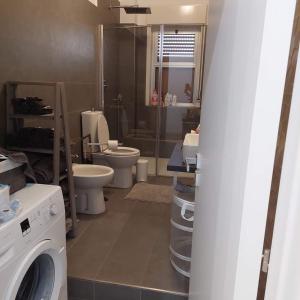 a bathroom with two toilets and a washing machine at Appartamento Agrumi in Linguaglossa