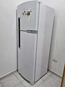 a refrigerator in a room with a white wall at Departamento en el centro de la ciudad in Mercedes