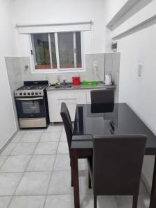 a kitchen with a stove and a table with chairs at Departamento en el centro de la ciudad in Mercedes +5 photos