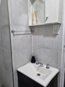 a bathroom with a white sink and a mirror at Departamento en el centro de la ciudad in Mercedes