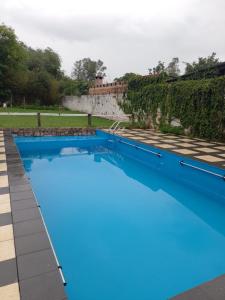 uma grande piscina com água azul em Cabañas La Caballeriza San Lorenzo em Salta