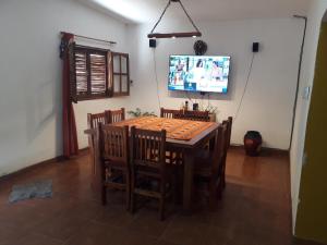 una sala da pranzo con tavolo, sedie e TV di Pillanhuasi alquiler por dia a Villa Unión