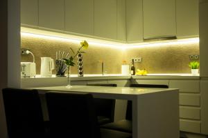 a kitchen with white cabinets and a counter top at Matei Corvin Deluxe Apartment in Cluj-Napoca +143 photos