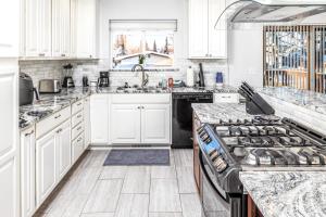 a kitchen with white cabinets and a stove top oven at Midtown Anchorage Basecamp Condo A in Anchorage