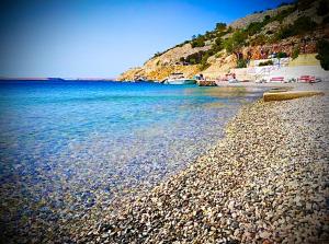 a rocky beach with boats in the water at Rooms Florida in Tribanj-Krušćica