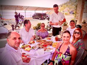a group of people sitting around a table with food at Rooms Florida in Tribanj-Krušćica