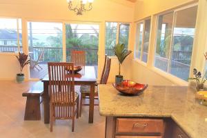 a kitchen with a table and chairs and a dining room at Hawaiian Paradise in Keaau