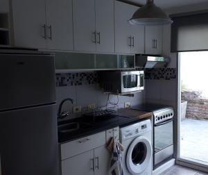 uma cozinha com uma máquina de lavar roupa e um micro-ondas em Comoda casa con inmejorable ubicación y servicios em Fray Bentos