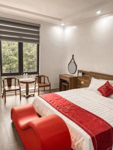 1 dormitorio con 1 cama grande, mesa y sillas en Hotel A18 Lào Cai, en Lào Cai