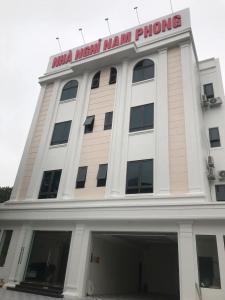 un gran edificio blanco con un cartel. en Nam Phong Hotel, en Phú Nặng