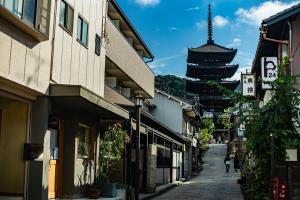 a street with buildings and a tower in the background at Oakwood Hotel Oike Kyoto in Kyoto