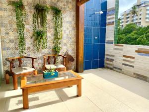 a bathroom with two chairs and a table and a shower at Cobertura Duplex: piscina, três quartos e beira á mar in Ilhéus