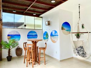 a room with a table and chairs and a wall with round windows at Cobertura Duplex: piscina, três quartos e beira á mar in Ilhéus