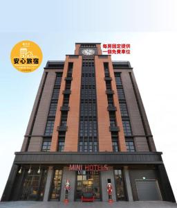 un edificio alto con un reloj encima en MINI HOTELS (Feng Jia Branch) en Taichung