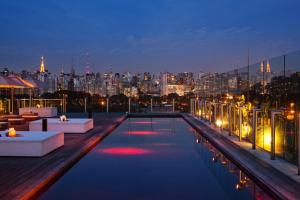 una piscina en la azotea con vistas a la ciudad por la noche en Hotel Unique, en São Paulo