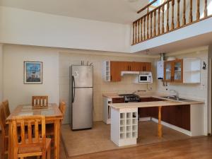 a kitchen with a refrigerator and a table at Casas Isla Negra in El Quisco
