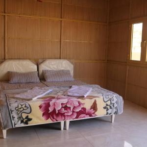 a bedroom with a bed with flowers on it at Abu Omair Jabal Shams House in Al Ḩamrāʼ