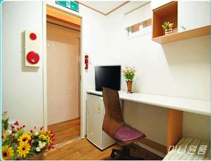an office with a desk and a chair and flowers at Asan Residence in Seoul