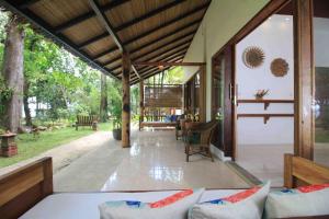 Murex Dive Resort في مانادو: شرفة مفتوحة للمنزل مع فناء
