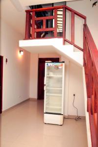 a large refrigerator in a room with a staircase at Pearl Mirissa in Mirissa