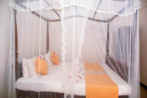 Un dormitorio con una cama con dosel y cortinas blancas. en Pearl Mirissa, en Mirissa 53 fotos más