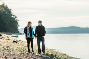 un homme et une femme se promenant sur la plage dans l'établissement The Edenwild Boutique Inn, à Lopez