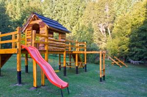 un parque infantil con tobogán y una casa de juegos en Tillka - Casas de Montaña en Villa La Angostura