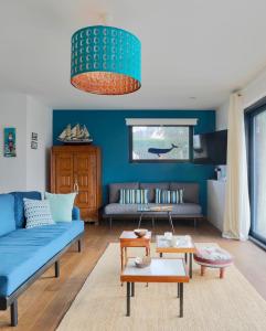 トレガステルにあるÀ L'Accostageの青い壁のリビングルーム(青いソファ付)