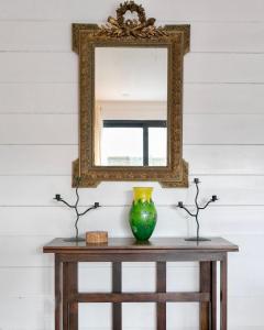 ein Spiegel auf einem Tisch mit einer Vase darauf in der Unterkunft À L'Accostage in Trégastel