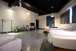 a room with three beds and a tv in it at View Hostel in Hualien City