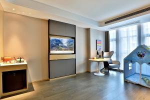 a room with a desk and a table and a window at Atour Hotel Nanjing Olympics Sports Center CBD in Nanjing