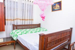 a bedroom with a bed with a green and white comforter at Rashmi HomeStay in Balapitiya