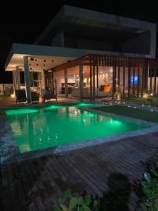 a swimming pool in front of a house at night at Casa Encanto dos Milagres in São Miguel dos Milagres +11 photos