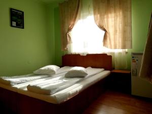 ein Bett in einem grünen Zimmer mit einem Fenster in der Unterkunft Casa Leah in Râșnov