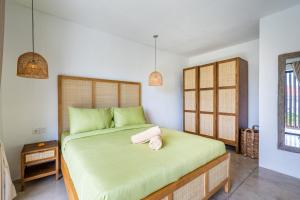 a bedroom with a large bed with green sheets at Terrace B3 Villa by Betterplace in Dalung +23 photos