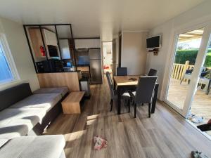 ein Wohnzimmer und eine Küche mit einem Tisch und Stühlen in der Unterkunft Mobil Home 2022 les charmettes 3 Chambres 40m2 in Les Mathes